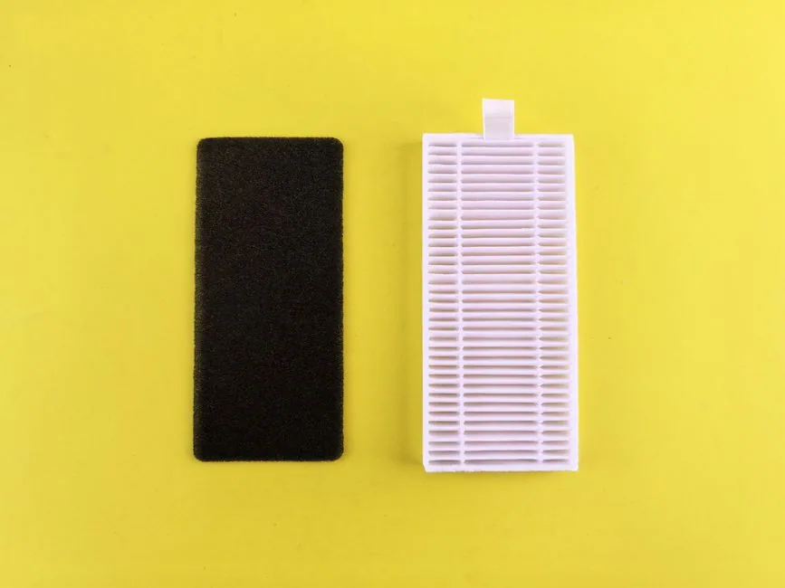 A pleated air filter partially pulled out of a white air purifier housing