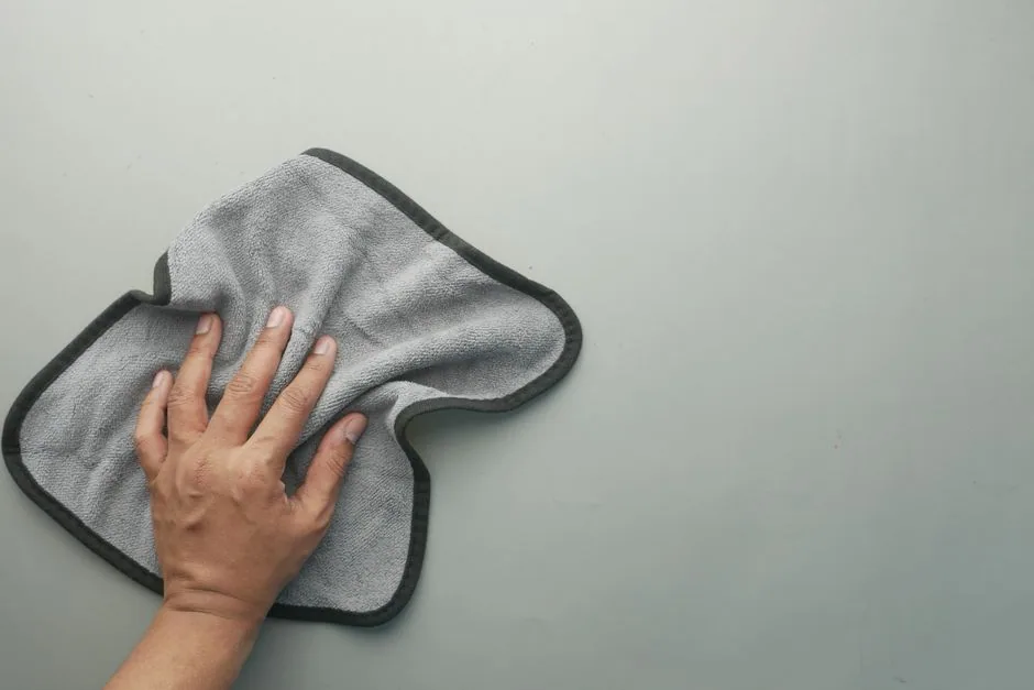 hand wiping a table with cloth