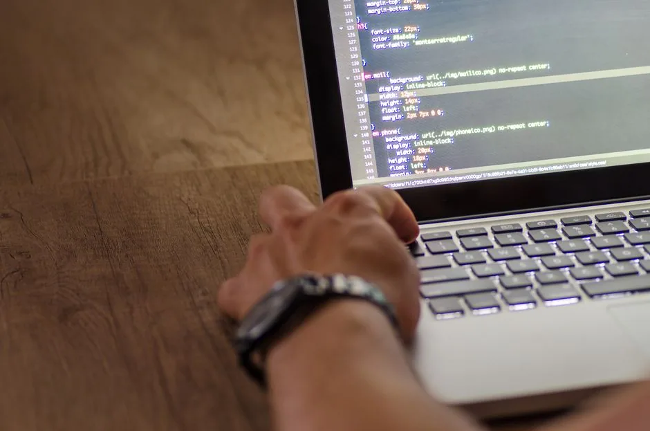 developer hand interacting with code on laptop
