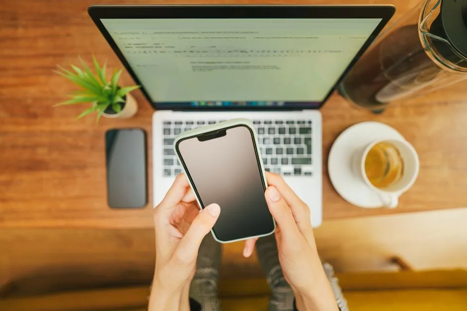 A smartphone beside a laptop during email account setup