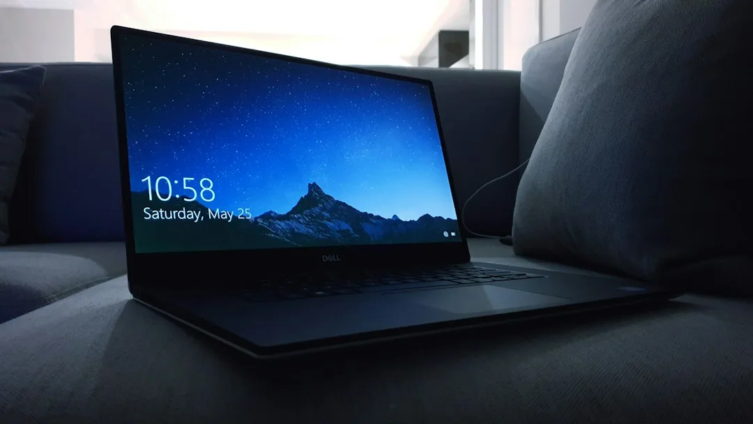 소파 위에 놓인 검은색 Dell 노트북