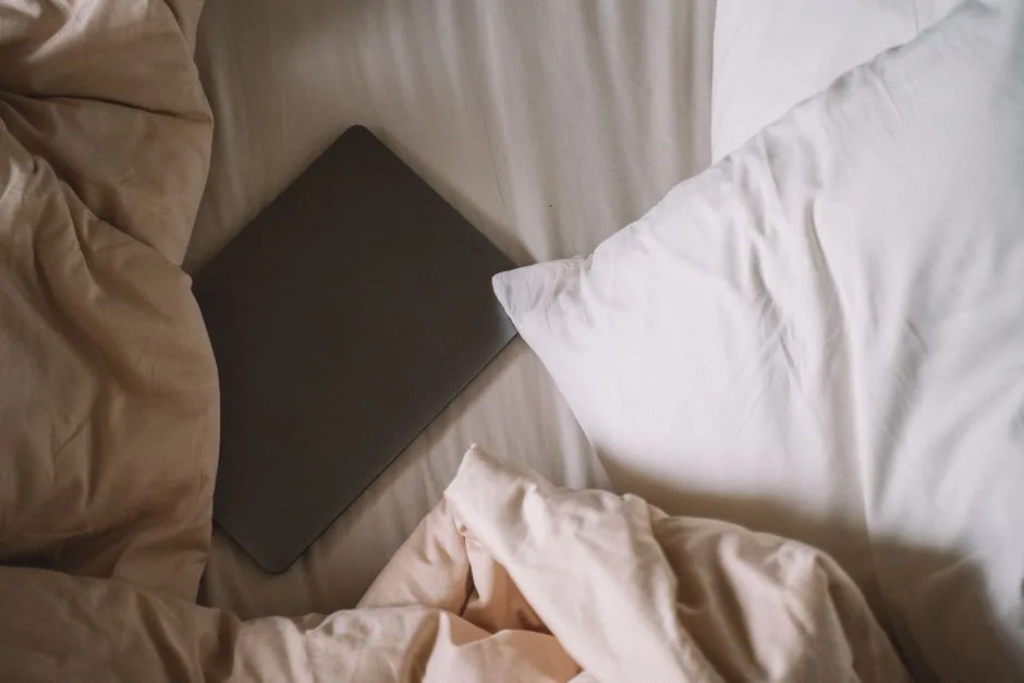 laptop resting on unmade bed